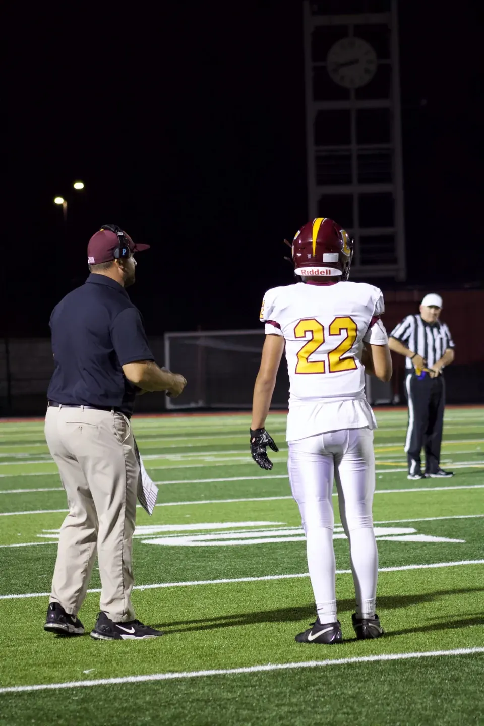 Logan Gadbois in his number 22 jersey beside another person on the sideline.